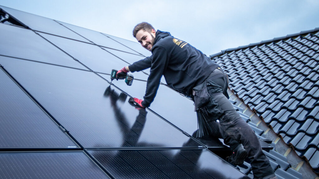 Ein Monteur von Nordic Sunpower verbohrt ein PV-Modul auf einem Hausdach.