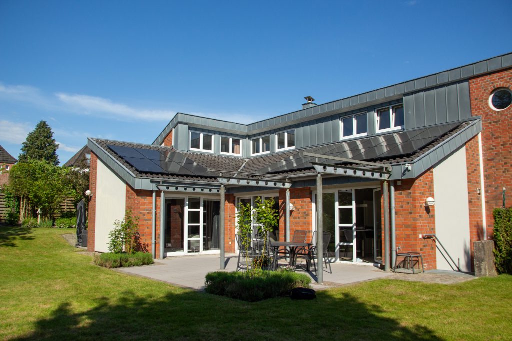 Frontalansicht auf ein verwinkeltes Hausdach mit mehreren PV-Modulen.