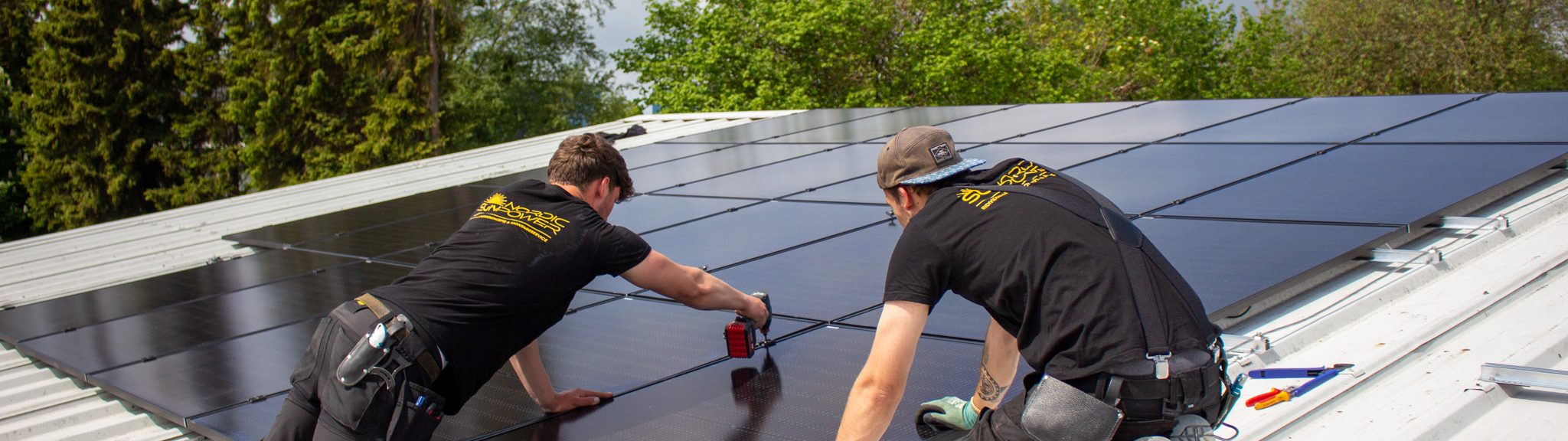 Zwei Handwerker von Nordic Sunpower bei der Montage einer PV-Anlage auf einem Dach.