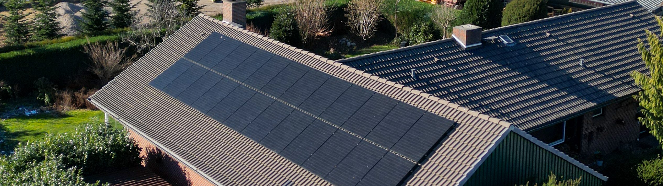 Eine PV-Anlage auf einem länglichen Dach eines Hauses.